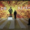 Ein Besucher posiert vor einer Statue von Lei Feng in der Ausstellung «Learn from Lei Feng Day» im Beijing World Art Museum - Beijing, China. (Keystone/EPA/How Hwee Young)